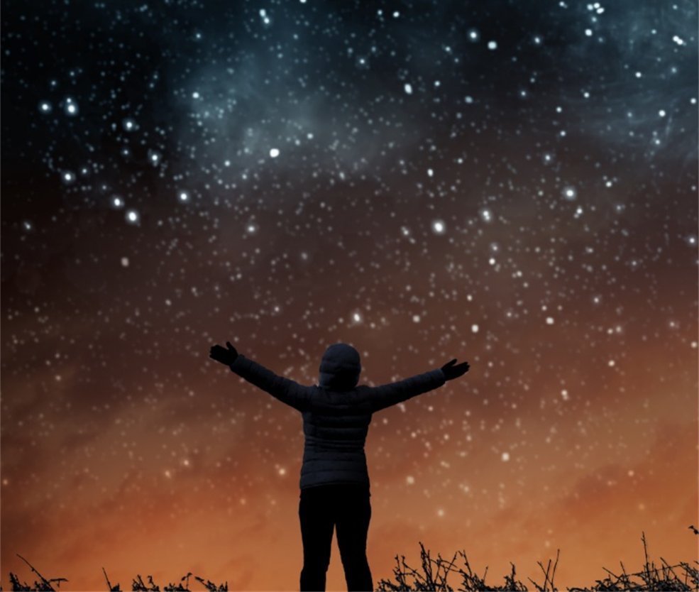 A woman with her arms upraised to the stars.